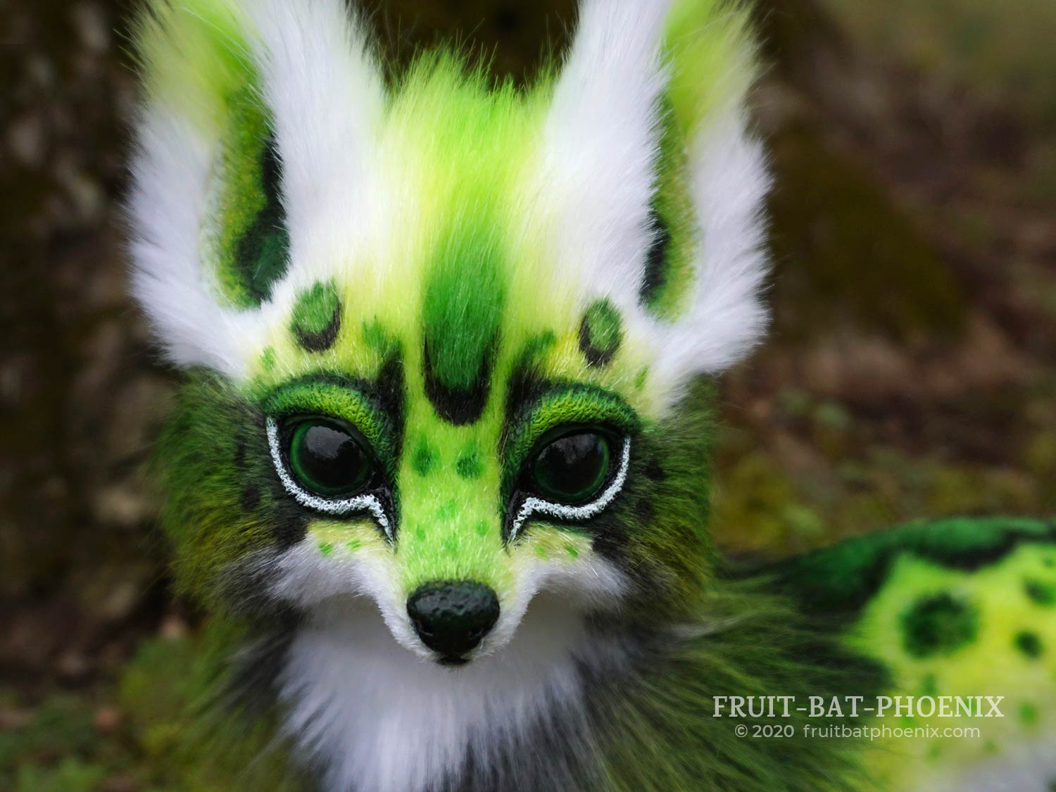 Face closeup of green spotted fox posable art doll.