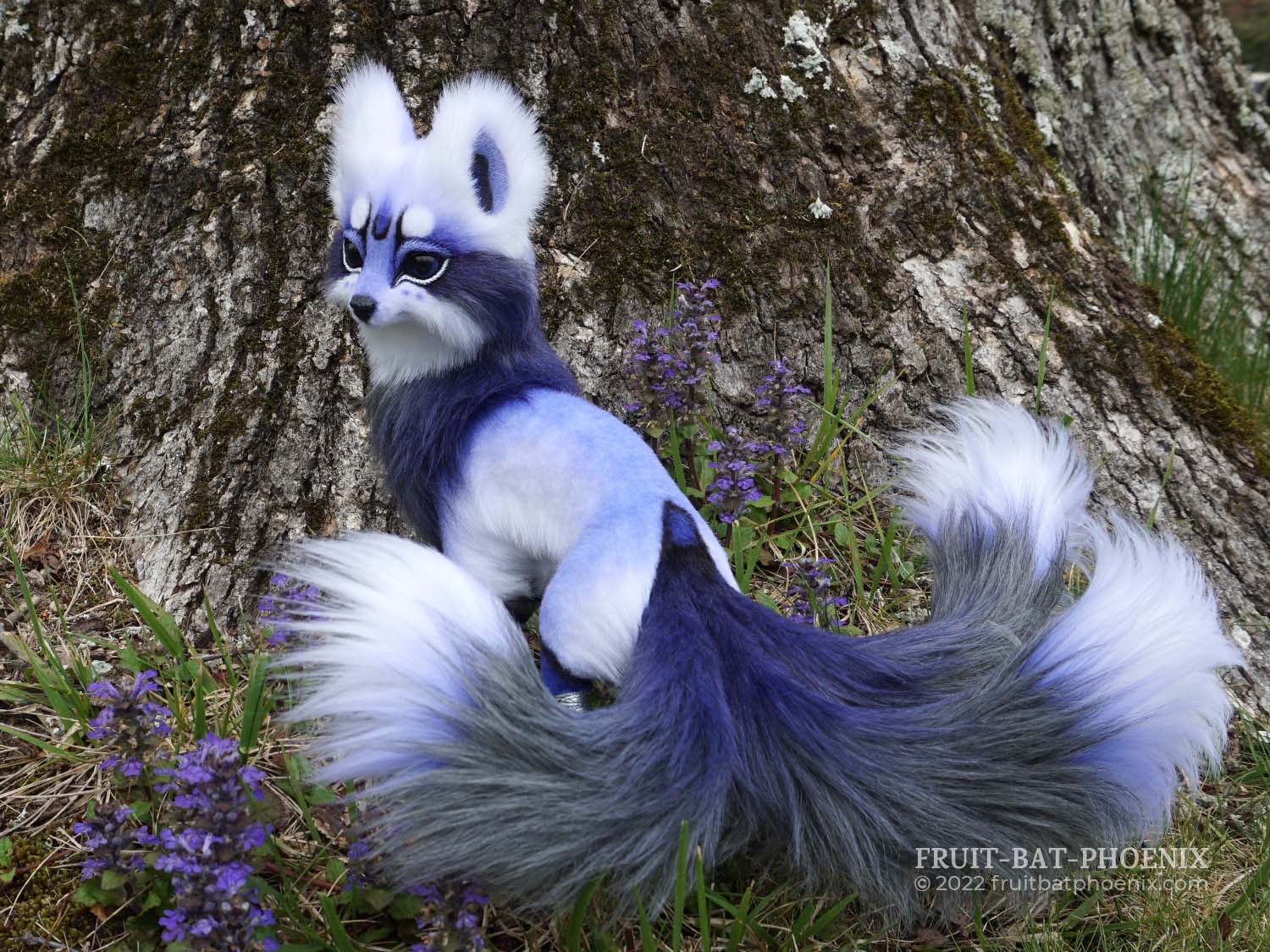 lavender, white, and silver grey fox poseable art doll looks over her shoulder. the fox has three tails