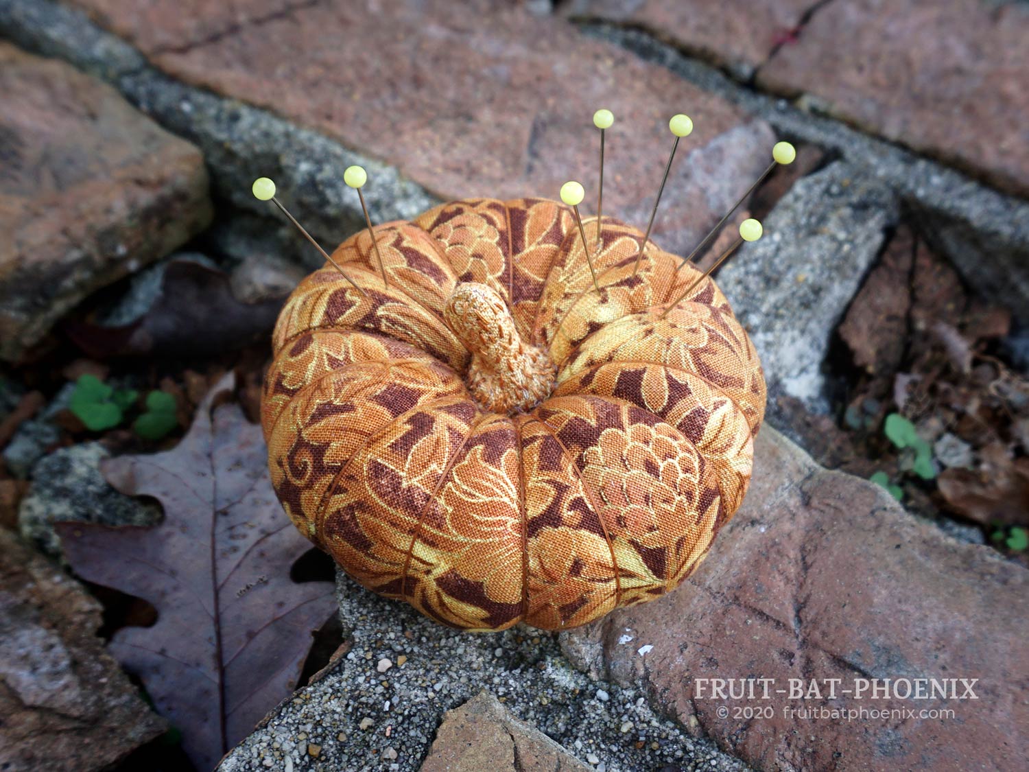 Golden plush pumpkin pincushion with pins