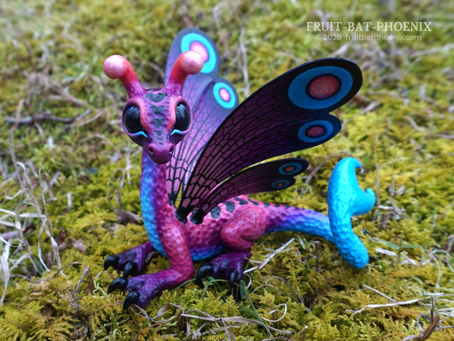 purple, blue, and pink dragon with butterfly wings and antennae